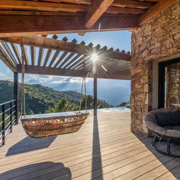 Balançoires et fauteuils face à la piscine à débordement - Villa Nature - Espaces extérieurs