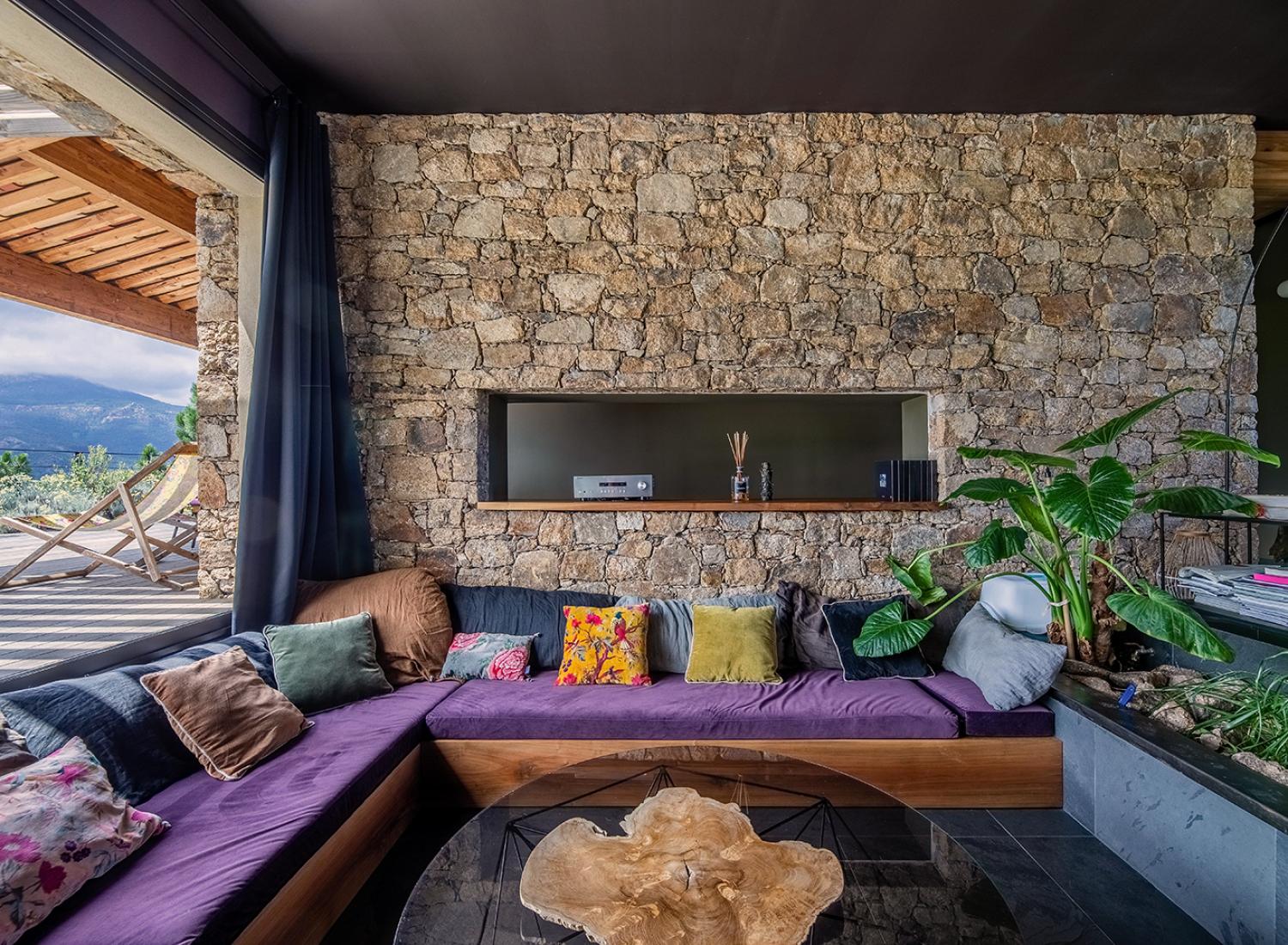 Salon encastré et son mur de pierres corses traditionnel - Villa Nature - Espaces de vie